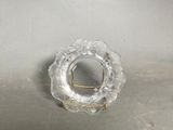a small glass plate with a gold handle on a table