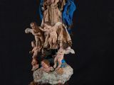 a statue of the virgin with angels and chers on a black background