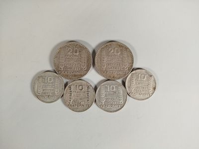 six pièces d'argent empilées les unes sur les autres sur une surface blanche
