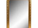 a gold framed mirror sitting on top of a white surface