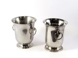 two silver cups sitting next to each other on a white surface