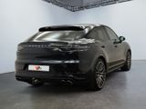 the rear of a black porsche cayen is shown in a showroom