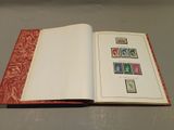 an open book with stamps on it sitting on a table