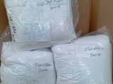 plusieurs sacs contenant des oreillers blancs posés sur une boîte en carton