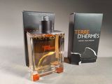 the bottle of the perfume is next to the box on the table