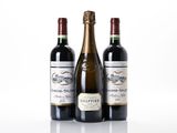 trois bouteilles de vin posées les unes à côté des autres sur une surface blanche