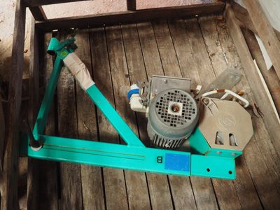 une machine verte posée sur un plancher en bois