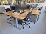 two desks with computers on them in an office