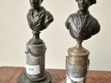 pair of bronze busts of a man and a woman on a pedestal