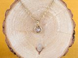 Collier plaqué or jaune orné d'un diamant blanc sur une tranche d'arbre