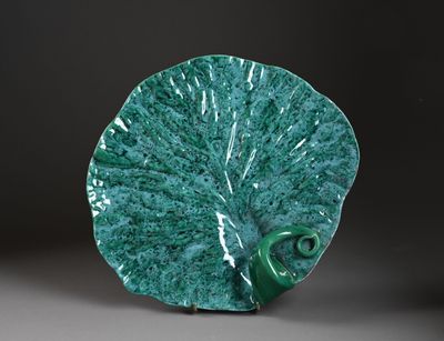 une assiette verte ornée d'un motif en forme de feuille