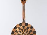 a guitar hanging from a string on a white wall