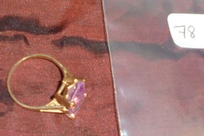 une bague en or sertie d'une pierre violette
