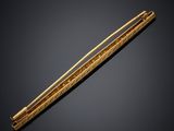 an image of a gold plated chopstick on a black background