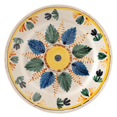 a yellow and blue plate with leaves on it