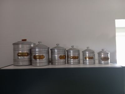 five metal containers sitting on top of a counter