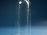 an empty glass bottle on a table with a blue background