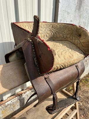 a wooden bench with a saddle on top of it