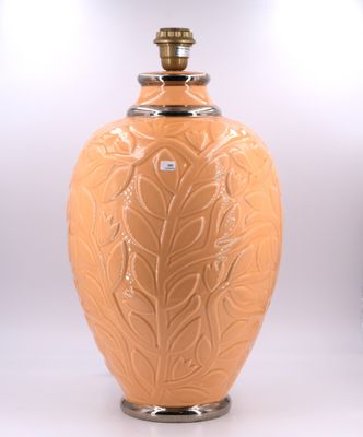 un grand vase orange orné d'un motif de feuilles