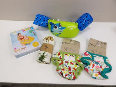 a table with various baby items on it including a banana, diapers, and a book