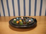 a bowl of marbles on a table with a striped wall behind it