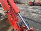a red excavator that is parked in the parking lot