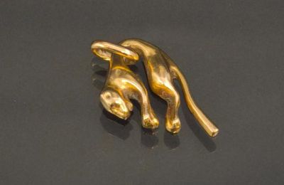 a gold sculpture of a cat on a black surface