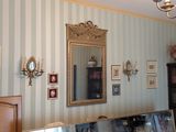 un miroir accroché au mur d'une pièce aux murs rayés