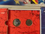 two books and a coin sitting on top of a table next to each other