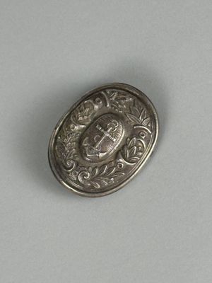 une image représentant un bouton en argent orné d'une couronne