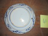 une assiette bleue et blanche posée sur une table, avec un autocollant jaune à côté