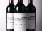 trois bouteilles de vin rouge sont alignées sur une table
