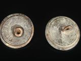 pair of antique brass buttons on a black background