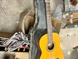 a guitar that is sitting on the floor next to a pile of boxes