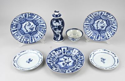 plusieurs assiettes et bols bleus et blancs ainsi qu'un vase posés sur une table