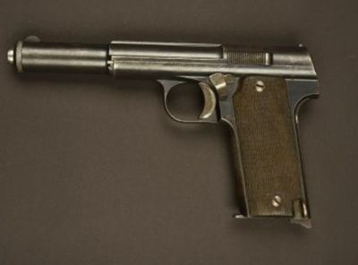 un vieux pistolet posé sur une table, sur fond marron