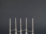 un ensemble de quatre bougies argentées posées sur une table noire