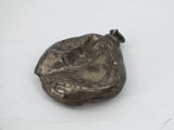 a metal object that is sitting on a white surface