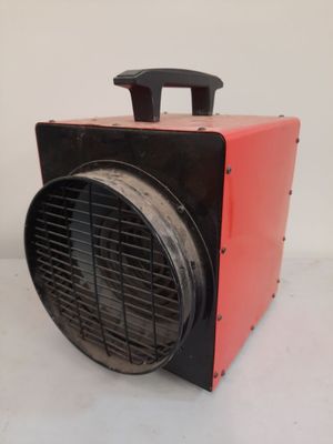 a red and black heater sitting on a white surface
