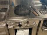 une grande cuisine en inox équipée d'une cuisinière et d'un évier