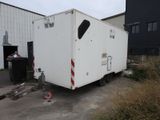 a white trailer that is parked in front of a building