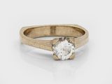 a close up of a gold engagement ring with a white diamond