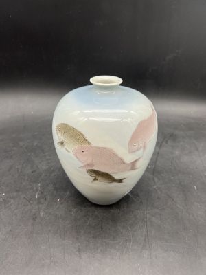un petit vase blanc orné d'un motif d'oiseau