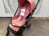 the baby stroller is pink and has a black handlebar
