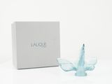 a small glass bird figurine sitting next to a box