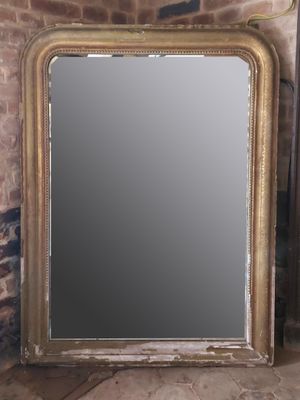 un miroir posé par terre devant un mur de briques