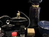 many different types of perfume bottles on a black surface