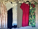 un grand nombre de robes suspendues à une étagère dans une pièce