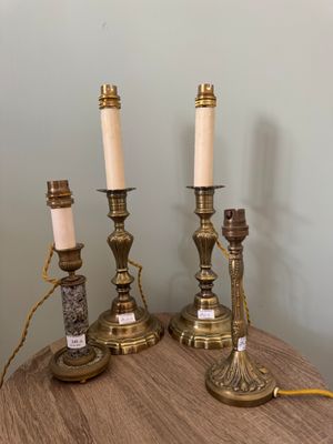 Trois bougies sont posées sur une table en bois près d'un mur.