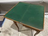 a small table with a green top sitting on the floor